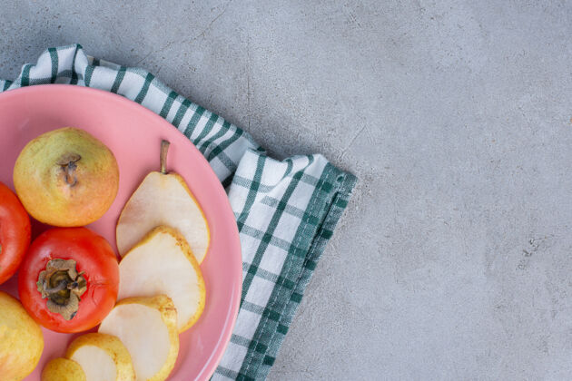 毛巾一个水果拼盘 在毛巾上放梨和柿子 背景是大理石配料梨新鲜