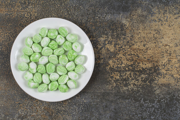 香料白色盘子上的绿色薄荷醇糖果糖果薄荷邦邦
