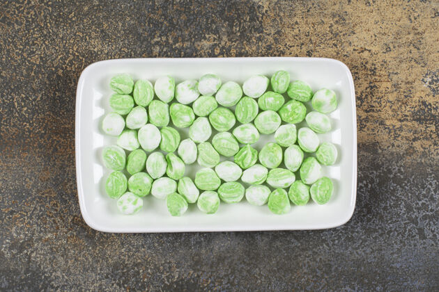 薄荷一堆绿色薄荷醇糖果放在白色盘子里香料邦邦薄荷