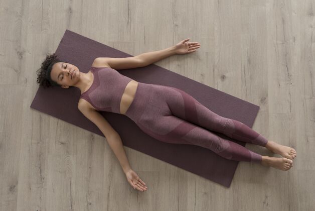 心灵健身女士在家里用瑜伽垫做瑜伽位置灵活瑜伽
