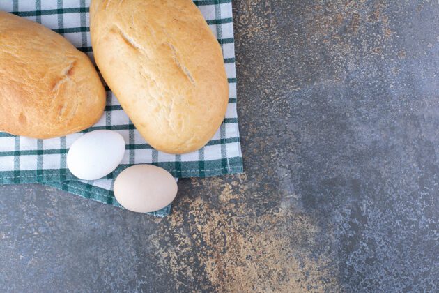 产品面包和鸡蛋陈列在大理石表面的毛巾上馒头鸡蛋酵母