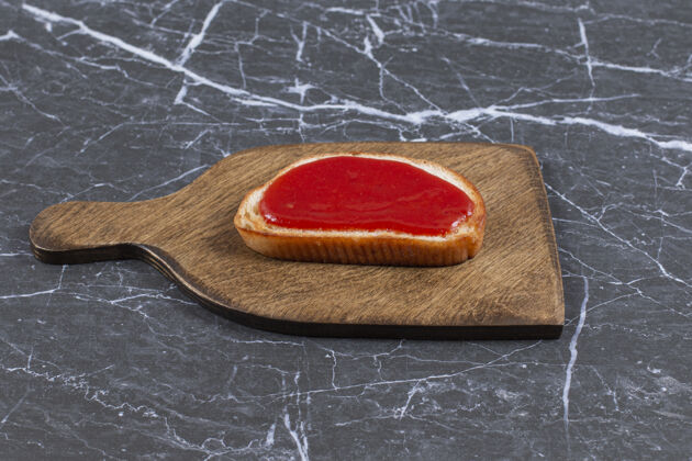 烘焙食品把草莓酱放在面包上 放在木板上 大理石表面面包面包板子