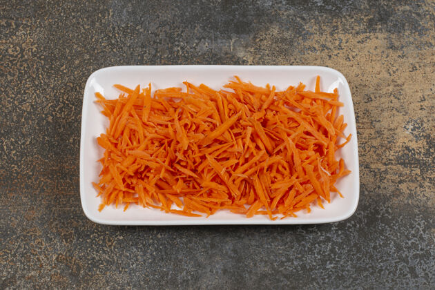 沙拉白盘子里放着美味的胡萝卜新鲜剁碎小吃