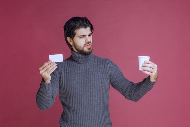 职员拿着咖啡杯展示账单或名片的男人模特人休闲
