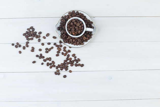 咖啡顶视图咖啡豆在杯子和茶碟在木制背景上水平食物烤新鲜的