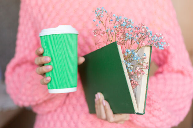 学习一个女人拿着一本打开的书 里面有一束干花和一杯咖啡女花束故事