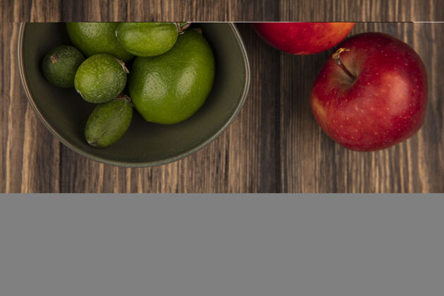 美味在一个碗上放着新鲜的酸橙 红色的苹果被隔离在一个木制的表面上肥肉食物木材