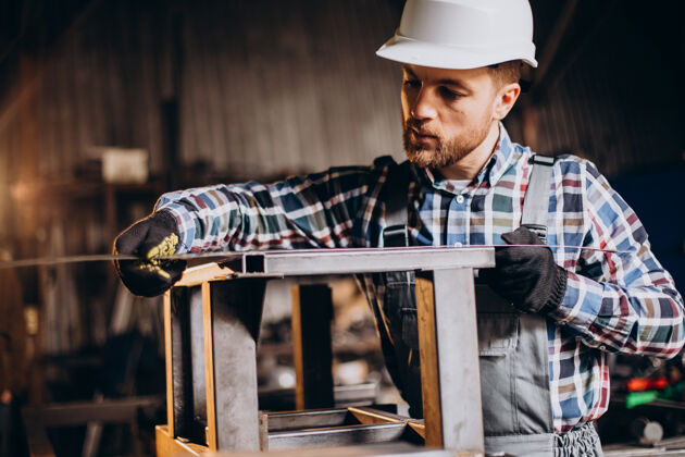 工具工厂里戴着测量尺的帽子的工人手工人金属加工