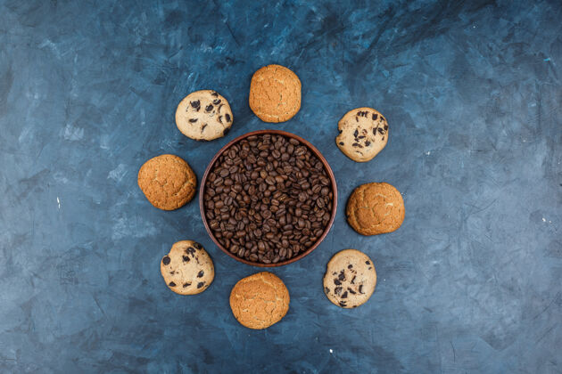 饼干把咖啡豆平放在碗里 在深蓝色的背景上放上不同类型的饼干水平美味的蛋糕桌子