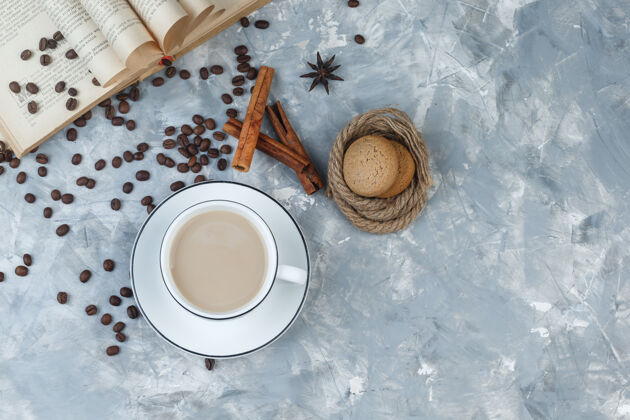 早餐顶视图咖啡杯饼干 咖啡豆 书 香料灰色石膏背景水平咖啡热新鲜
