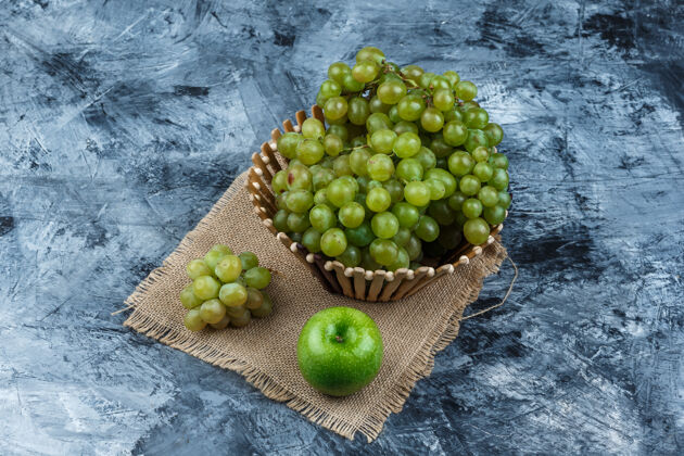 浆果一套苹果和绿葡萄在一个篮子里的垃圾和一块袋子的背景高角度视图成熟健康集