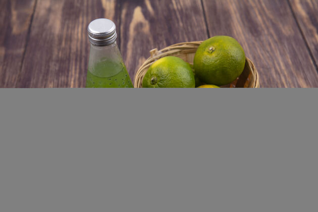 前面正面图：橘子放在篮子里 梨子猕猴桃和一瓶果汁放在木墙上柑橘视野食品
