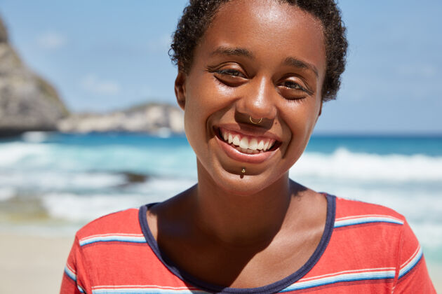 理发特写镜头民族妇女牙齿微笑 穿着休闲服健康海岸风景