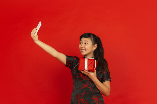 祝福新年快乐红色背景上孤立的亚洲少女肖像肖像风格服装