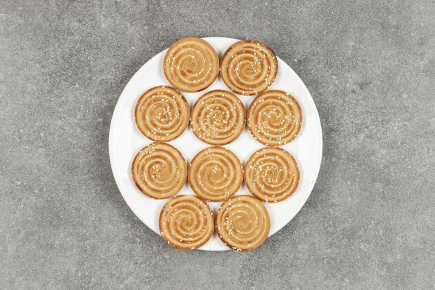 小吃一盘美味的圆饼干放在大理石表面饼干金黄的脆