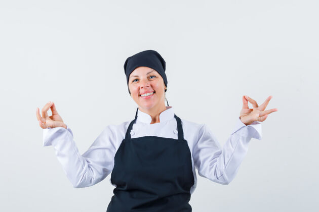健康穿着黑色厨师制服的金发女人展示冥想姿势 看起来很漂亮前视图冥想手势护理
