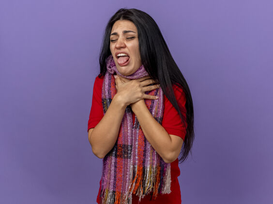 磨损疼痛和恼怒的年轻白种女孩戴着围巾拿着喉咙闭着眼睛隔离在紫色墙上复制空间疼痛喉咙烦躁