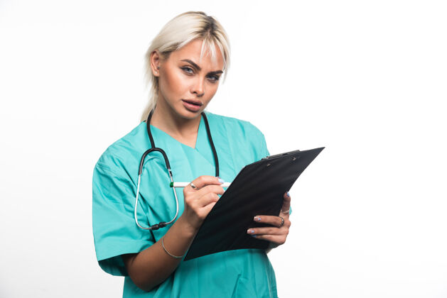 女性女医生用白纸笔在剪贴板上写东西女士拿着工作