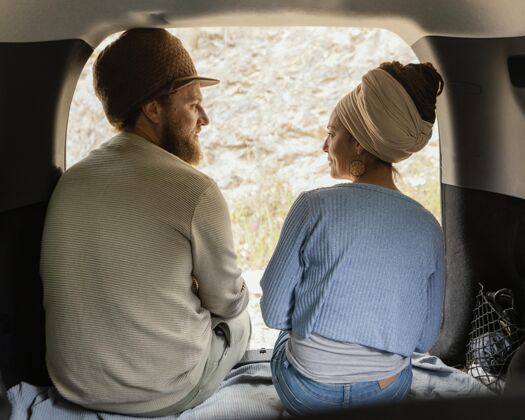后视图坐在车里的一对夫妇家庭旅行探索