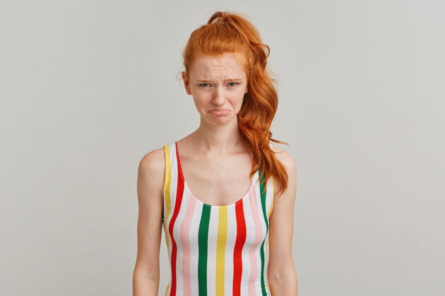 皮肤心烦意乱的女人 不幸的红发女孩 马尾和雀斑 穿着条纹彩色泳衣情感模特美丽