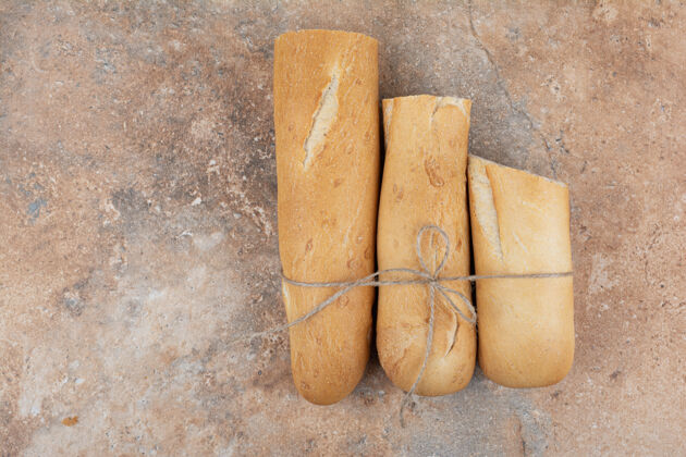 绳子大理石背景上的半切面包面包房切的新鲜
