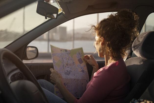 世界车里拿着地图的中枪女人度假旅游中镜头
