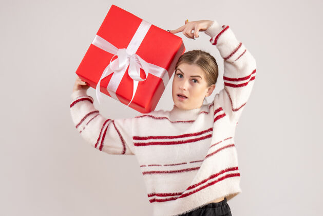 年轻女性年轻的女性拿着白色的红色礼物礼物圣诞节人