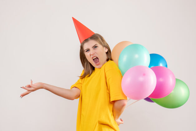 背影年轻的女性把彩色的气球藏在白色的背上风景人生日
