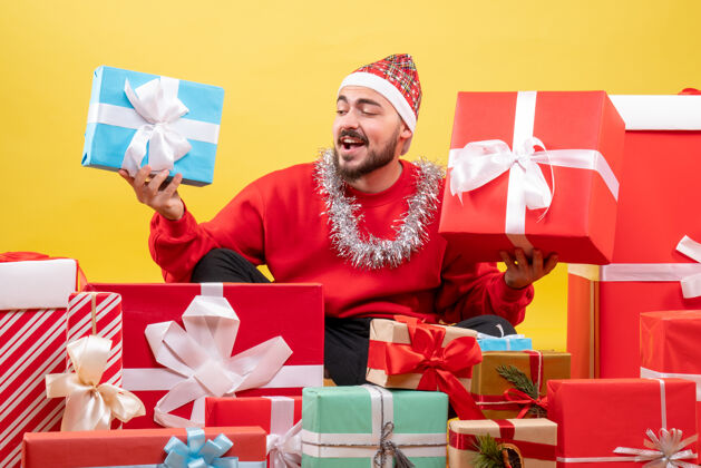 盒子正面图：年轻男性围坐在黄色背景上的圣诞礼物旁购物年礼物