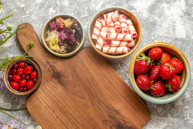 浆果顶视图新鲜的红色草莓与白色表面上的花朵浆果红色糖果花食物新鲜的红草莓