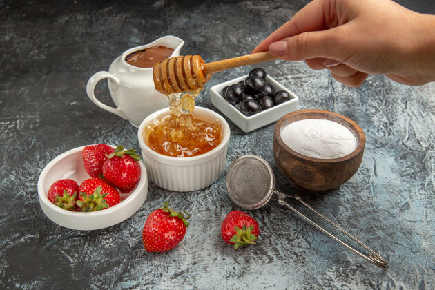 咖啡正面图新鲜草莓加蜂蜜 表面呈深色水果甜果冻食物果冻碗新鲜草莓