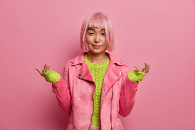 颜色不知犹豫的粉红鲍勃发型女人困惑地举手 不知道发生了什么毛衣时尚女士