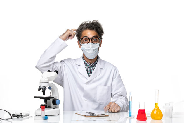 实验室正面图身着特殊套装的中年科学家坐着写笔记坐化学化学