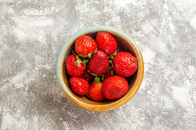 少顶视图新鲜的红色草莓在白色表面上的小罐子水果红色草莓观新鲜甜点