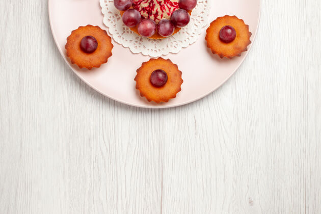 食物顶视图美味的蛋糕与葡萄在盘子里放在白色的桌子上 派甜点蛋糕蛋糕盘子甜点