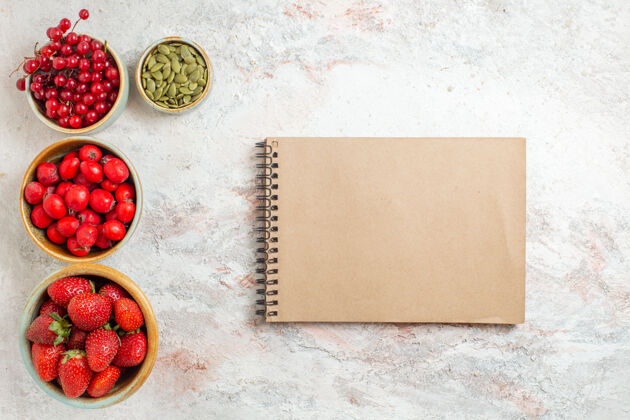 浆果顶视图新鲜草莓配红色水果 白色桌上草莓水果新鲜笔记本红色信封