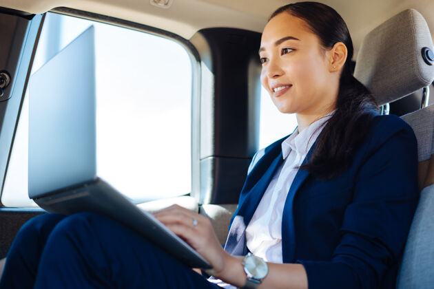 成人互联网连接一个在车上用笔记本电脑工作的女人正在使用互联网连接亚洲人女性赛车