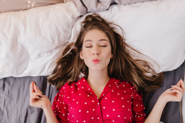 表情迷人的女孩在床上冥想头顶上的照片是一位漂亮的黑发女士闭着眼睛放松快乐卧室寒冷