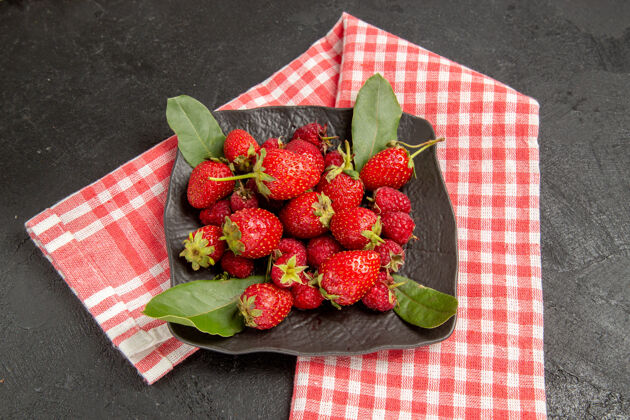 甜点半顶视图新鲜的红色草莓在盘子里放在深色的桌子上颜色新鲜成熟的草莓颜色多汁食物