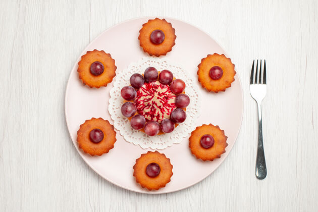 饼干俯瞰美味的蛋糕加葡萄的白色桌上饼干派甜点季节餐钱包