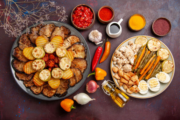 盘子俯视图美味的烤蔬菜与蛋粉和调味料在深色背景上烤箱烹饪烤蔬菜的颜色美味烘焙烹饪