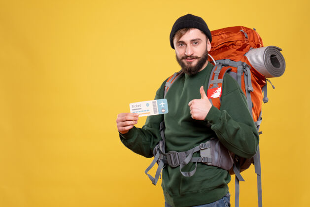 肖像旅行理念 带着微笑的年轻人 背着背包 拿着票 在黄色上做出ok的手势旅行高尔夫球手人