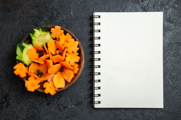 饮食顶视图切片设计沙拉与记事本上的灰色背景沙拉健康减肥蔬菜记事本测量仪器信封