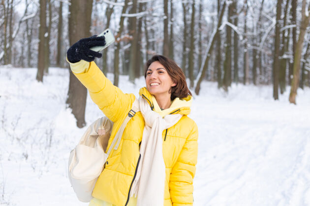 寒冷年轻美丽快乐开朗的女子在冬季森林视频博客 自拍照片美丽季节脸