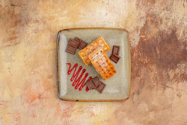 年代俯瞰美味的华夫饼与巧克力条在棕色的背景垃圾古董古董