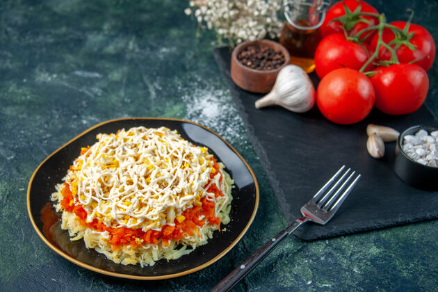 胡椒前视图含羞草沙拉内盘与调味品和红色西红柿在深蓝色的表面厨房照片美食生日食品节日餐色颜色里面风景
