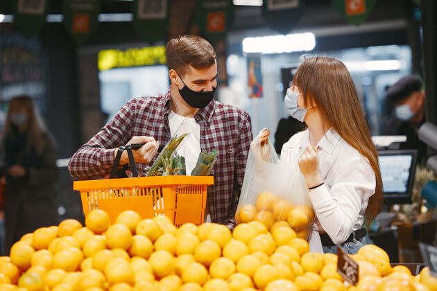 年轻人一对夫妇戴着医用防护面具在超市里购买疾病检疫