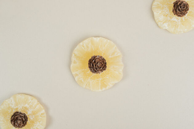 美味干菠萝片和松果放在米色的表面松果小吃圆形