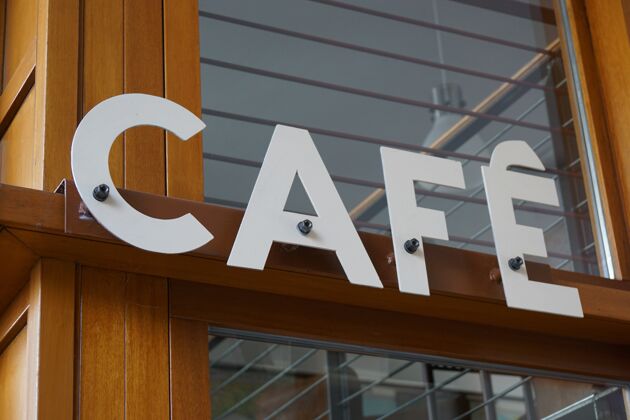 零售特写一个咖啡馆的标志固定在一个商店的木梁上服务标牌食品