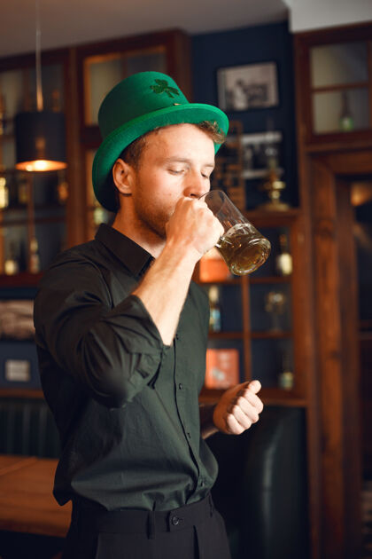 啤酒戴绿帽的卷发男人喝啤酒的男人在酒吧庆祝节日的男人庆祝留茬简介